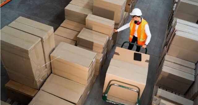 Image of a factory worker with packed goods ready for delivery