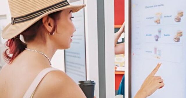 A lady using a Digital kiosk